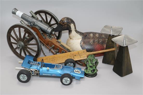 A model cannon, a decoy duck, a miniature 1938 cricket bat and three other items